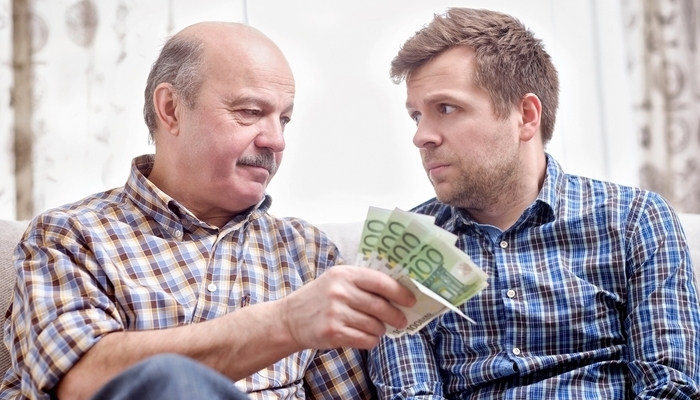 Padre dando dinero a su hijo