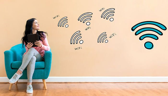 Chica sentada junto a imágenes del logo del WiFi