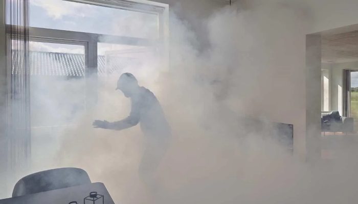 Ladrón rodeado de humo del sistema de seguridad de humo